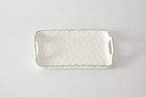 Rectangular ceramic tray with handles on a light gray background